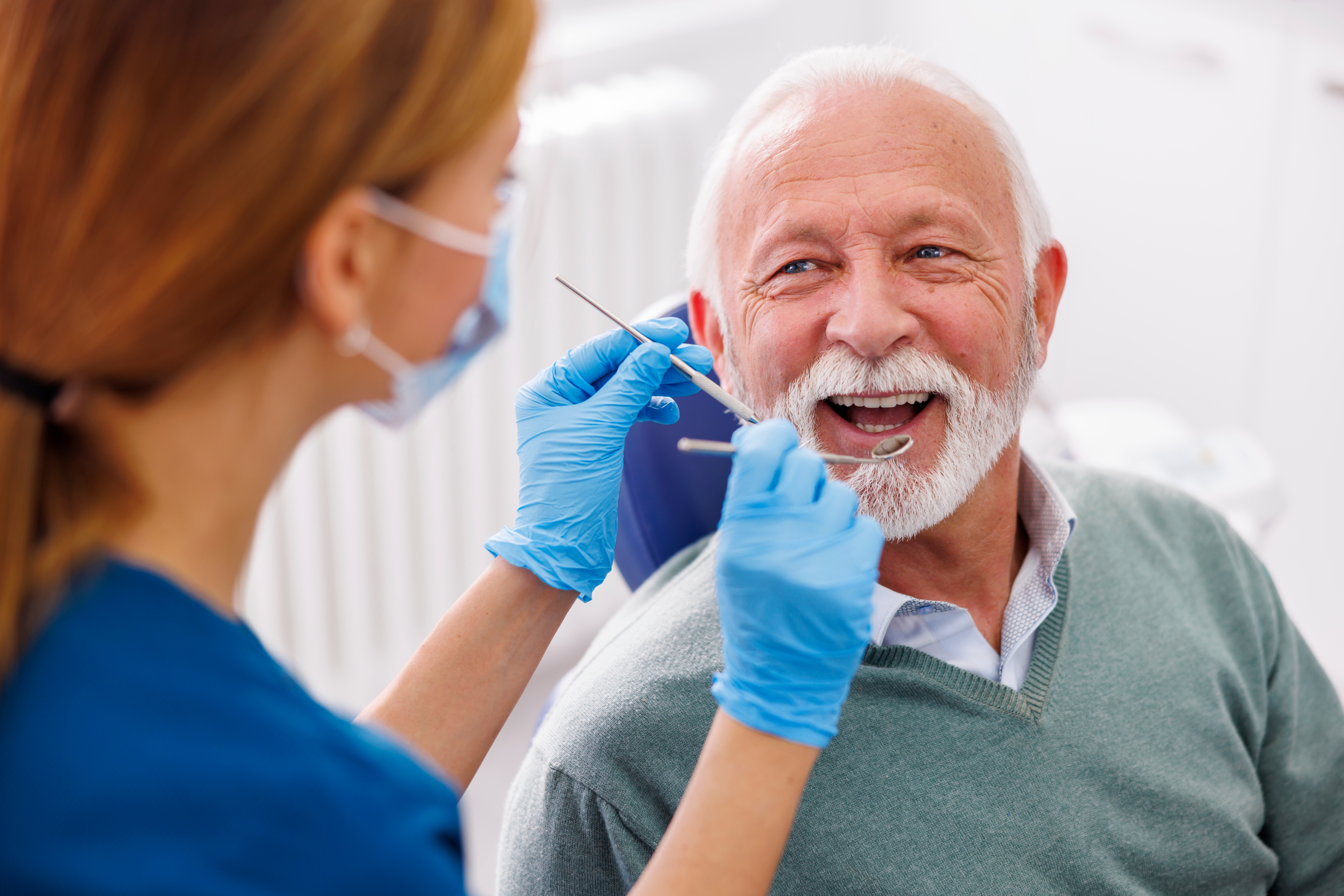Doctor checking older man's dental implants